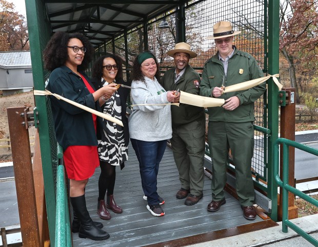 Opening the walkway during a ribbon cutting are Gary Chief Communication Officer Erica Blackwell, (left to right) Gary 1st District Council person Lori Latham, Founder of Brown Faces Green Spaces, Kimmie Gordon, Director of the Out Reach Program Kip Walton, and Park Superintendent Jason Taylor, Ph.D. The ceremony for the new pedestrian bridge at the Indiana Dunes National Park's Paul H. Douglas Center for Environmental Education took place on Monday, Nov. 4, 2024. (John Smierciak / Post Tribune)