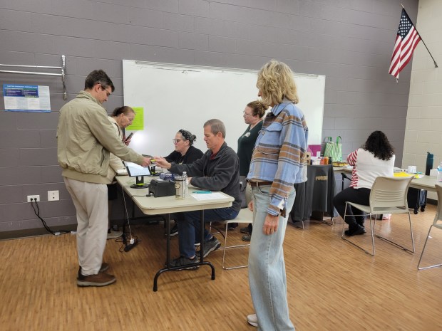 School City of Hammond teacher Anita Cox, left, talks to voters about school board candidates outside Lincoln Center in Highland Tuesday. Many canvassers stood outside from 6 a.m. to 6 p.m. helping voters make their choice. (Michelle L. Quinn/Post-Tribune)