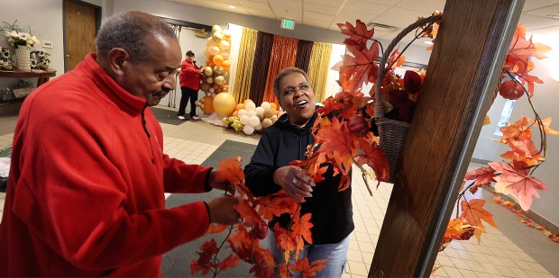 From left, State Rep. Vernon G. Smith, Alicia Hill and Shirley Cook hang decorations as volunteers set up for the Harvest Feast which is held in honor of Smith's mother, the late Rev. Julia E. Smith, and his aunt Magnolia Allen. The event included a short religious service followed by a traditional Thanksgiving dinner. The event was free and open to the public on Friday, Nov. 22, 2024. (John Smierciak / Post-Tribune)