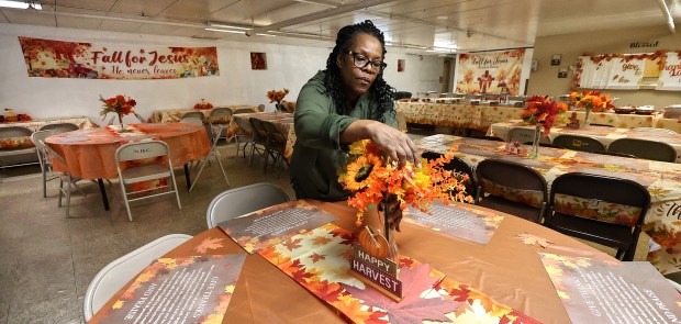 Pat Ware adjusts a table decoration as volunteers set up for the Harvest Feast which is held in honor of State Rep. Vernon G. Smith's mother, the late Rev. Julia E. Smith, and his aunt, Magnolia Allen. The event included a short religious service followed by a traditional Thanksgiving dinner. The event was free and open to the public on Friday, Nov. 22, 2024. (John Smierciak / Post Tribune)