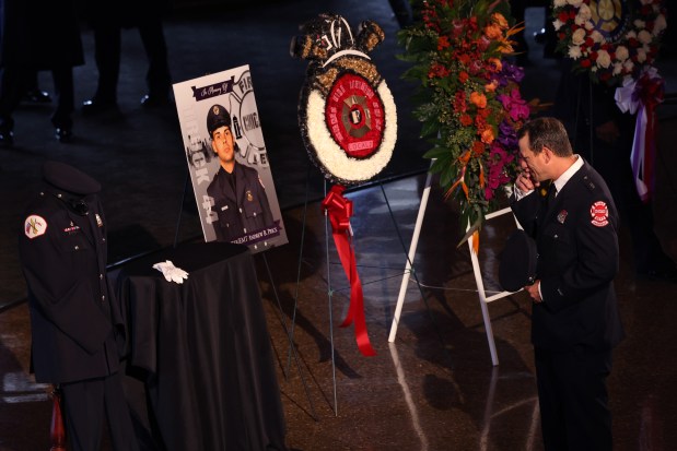 A firefighter pays his respects before the procession and the remembrance service for Chicago firefighter Andrew Price.