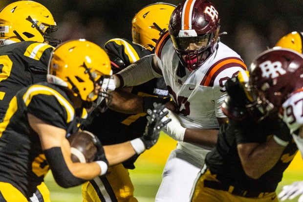 Brother Rice's King Liggins, center, has his one on St. Laurence's Cory Les during a CCL/ESCC crossover game in Burbank on Friday, Oct. 18, 2024. (Vincent D. Johnson / for the Daily Southtown)