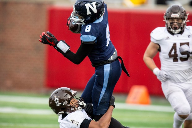 Nazareth Academy's Trenton Walker (8) is brought down by Joliet Catholic's Anthony Brown in the Class 5A state championship game at Hancock Stadium in Normal on Saturday, Nov. 30, 2024. (Vincent D. Johnson / for the Daily Southtown)