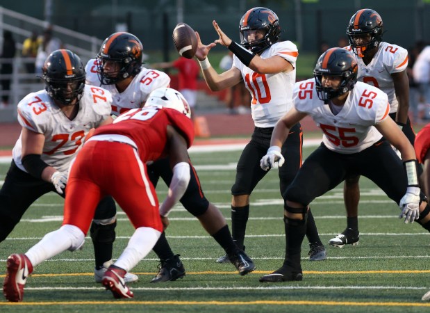 Lincoln-Way West's QB Chase Hetfleisch grads the ball as Eisenhower defends during football game in Blue Island on Friday, Aug. 30, 2024. (James C. Svehla / Daily Southtown)