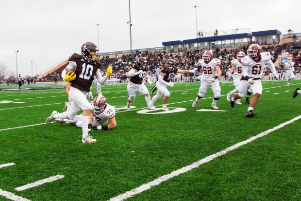 Joliet Catholic's Mikey Brow (10) returns his first interception to within a few yard of the goal line against Morris in the Class 5A state semifinals at Memorial Stadium in Joliet on Saturday, Nov. 23, 2024. (Vincent D. Johnson / for the Daily Southtown)