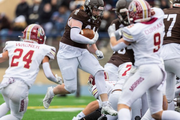 Joliet Catholic's Larry Stringham (24) leaps over a Morris defender in the Class 5A state semifinals at Memorial Stadium in Joliet on Saturday, Nov. 23, 2024. (Vincent D. Johnson / for the Daily Southtown)