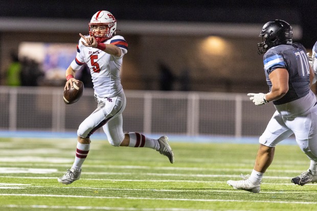 St. Rita's Steven Armbruster (5) tries to get a receiver open as he scrambles out o the pocket against Willowbrook in the Class 7A second-round game in Villa Park on Friday, Nov. 8, 2024. (Vincent D. Johnson / for the Daily Southtown)