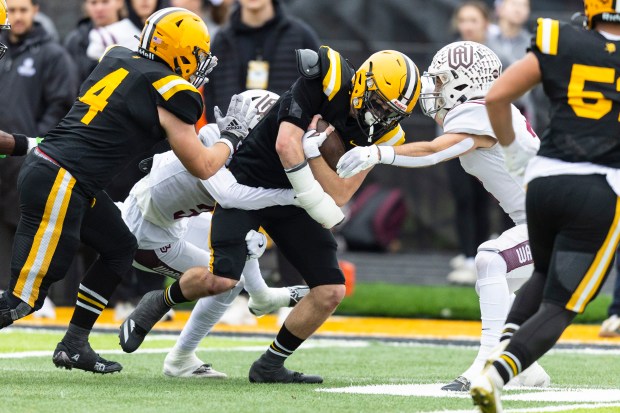 St. Laurence's Brendan Carroll drops a shoulder on one Wheaton Academy defender while he drags another after an interception during the Class 4A second-round game in Burbank on Saturday, Nov. 9, 2024. (Vincent D. Johnson / for the Daily Southtown)