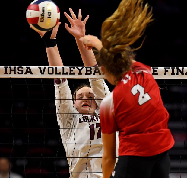 Marist's Bella Bullington (2) spikes the ball and /loc/17/ attempts to block it. Marist defeated Lockport Township 25-14, 25-22 in the IHSA Class 4A state tournament Semifinal game at the CEFCU Arena on the campus of Illinois State University in Normal, Nov. 15, 2024 (Rob Dicker / for the Daily Southtown)