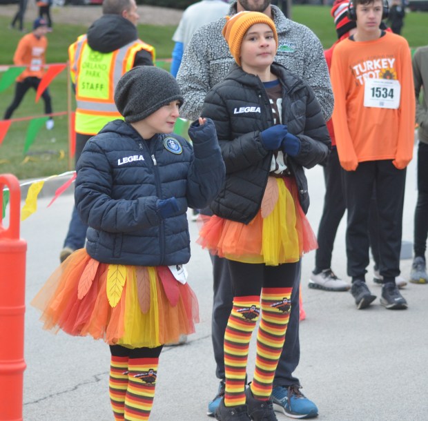 Lockport's Aleesa and Sofia Zeidan try to stay warm in their turkey attire before the Orland Park Turkey Trot Nov. 28, 2024. (Jeff Vorva/for the Daily Southtown)