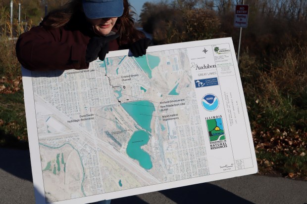 Kayla Lindsay Fisher, senior associate in stewardship for Audubon Great Lakes, shows birders a map of the drainage system connecting the hemi-marsh at the Powderhorn Prairie and Marsh Nature Preserve to Wolf Lake on Chicago's Southeast Side during a recent outing. (Susan DeGrane/Daily Southtown)