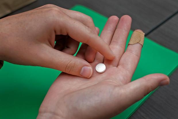 A patient prepares to take the first of two combination pills, mifepristone, for a medication abortion during a visit to a clinic in Kansas City, Kan., Oct. 12, 2022. (AP Photo/Charlie Riedel, File)