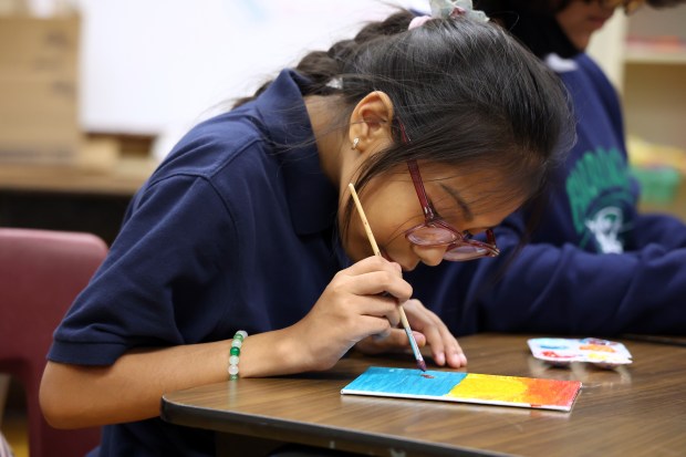 Student Cindy Salgado makes a painting during an after school program at Burroughs Elementary School in the Brighton Park neighborhood of Chicago on Oct. 3, 2024. The Brighton Park Neighborhood Council Chicago (BPNCC), an afterschool program that serves eight schools throughout the southwest side, has been among an estimated 120 sites in Chicago that have remained open in the midst of closures throughout the state. (Terrence Antonio James/Chicago Tribune)