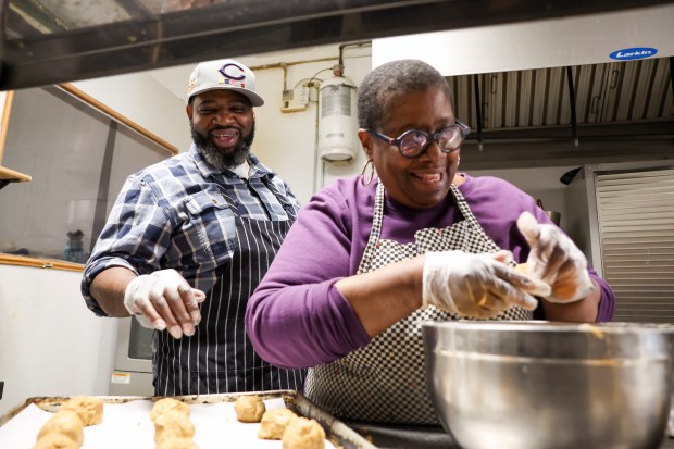 Vamarr Hunter laughs as he speaks to his mother Lenore Lindsey in the kitchen of their family-owned bakery, Give Me Some Sugah, in South Shore on Nov. 13, 2024. (Eileen T. Meslar/Chicago Tribune)