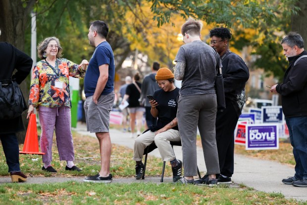 Logan Hoffman-Smith waits in a found chair in a line for early voting on Oct. 29, 2024, at Welles Park in Chicago. (Eileen T. Meslar/Chicago Tribune)