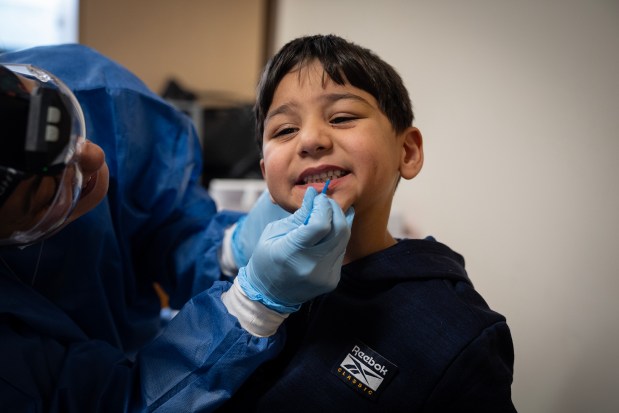 Dental assistant Leslie Hernandez applies flouride varnish to preschooler Jad Ahmed's teeth as the Mobile Care Chicago dental clinic visits Ridge Lawn Elementary School in Chicago Ridge, Nov. 22, 2024. (E. Jason Wambsgans/Chicago Tribune)