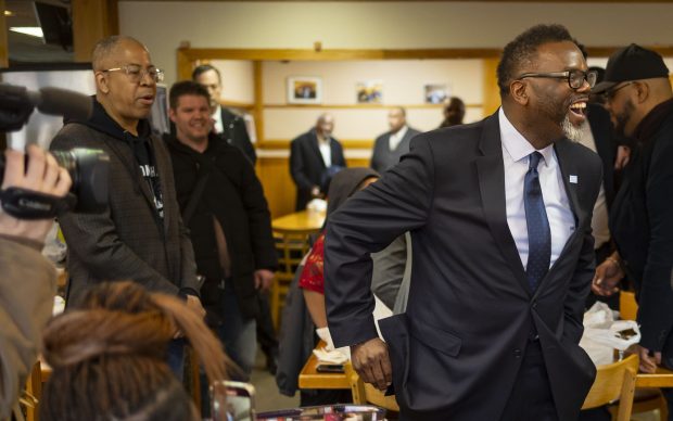 Then Mayoral aide Ronnie Reese, left, watches as Mayor-elect Brandon Johnson greets people at MacArthur's Restaurant in Austin on April 23, 2023. (Brian Cassella/Chicago Tribune)