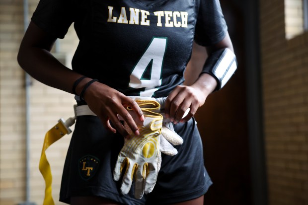 Lane Tech's Angel Ativie adjusts her flag belt with her gloves in the locker room before their first sectional game against Morton High School at Winnemac Stadium on Oct. 15, 2024. (Eileen T. Meslar/Chicago Tribune)