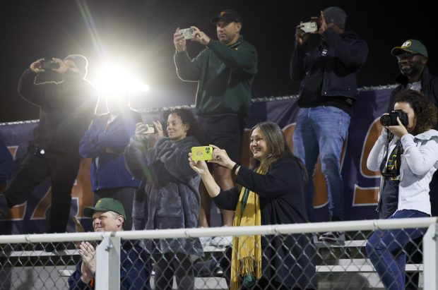 Lane Tech family members take photos of the team after they won the Oak Park-River Forest regional championship at Oak Park and River Forest High School on Oct. 10, 2024. (Eileen T. Meslar/Chicago Tribune)