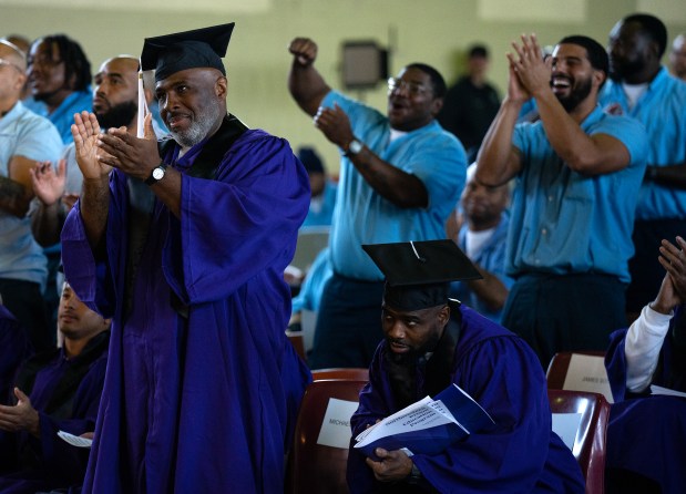 Michael Broadway, left, applauds a classmate during commencement ceremonies from the Northwestern Prison Education Program at Stateville Correctional Center, Nov. 15, 2023. (E. Jason Wambsgans/Chicago Tribune)