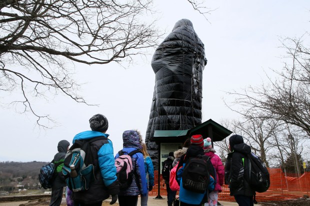 Fifth graders from Isaac Fox Elementary School in Lake Zurich gather around The Eternal Indian statue on April 6, 2018. The concrete statue, a beloved national landmark designed by renowned sculptor Lorado Taft, was dedicated in 1911. The statue is nearly 50-feet tall, weighs about 270 tons and stands on bluffs overlooking the Rock River in Lowden State Park. (Stacey Wescott/Chicago Tribune)