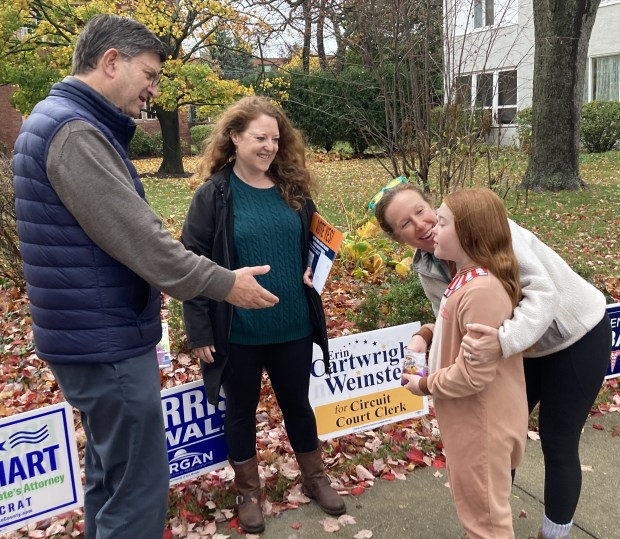 U.S. Rep. Brad Schneider, D-Highland Park, left, talks to voters and future voters in front of  Trinity Episcopal Church in Highland Park. (Steve Sadin/For the Lake County News-Sun)