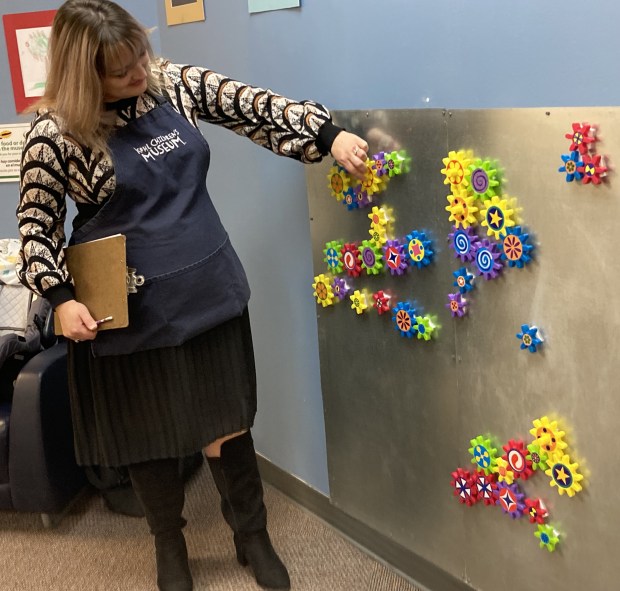 Mariel Spagnoli explains the gear wall at the Kohl's Children's Museum's Pop-Up Museum. (Steve Sadin/For the Lake County News-Sun)