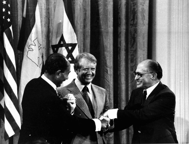 Egyptian President Anwar Sadat, from left, President Jimmy Carter and Israeli Prime Minister Menachem Begin shake hands during a White House announcement on Sept. 18, 1978, of the accord reached at the Camp David summit. (Associated Press)