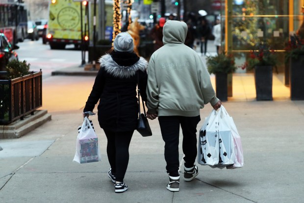 Shoppers walk on Chicago Avenue in Chicago Dec. 10, 2021. Retailers are concerned about security as "flash mob" retail thefts have hit Chicago stores. (Terrence Antonio James / Chicago Tribune)