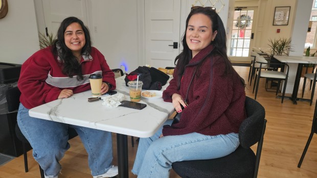 Erica Cepeda left, and Priscilla Diaz, both from Aurora, visit the newly-opened Atrevete Cafe 1888 in Aurora on Saturday. (David Sharos / For The Beacon-News)