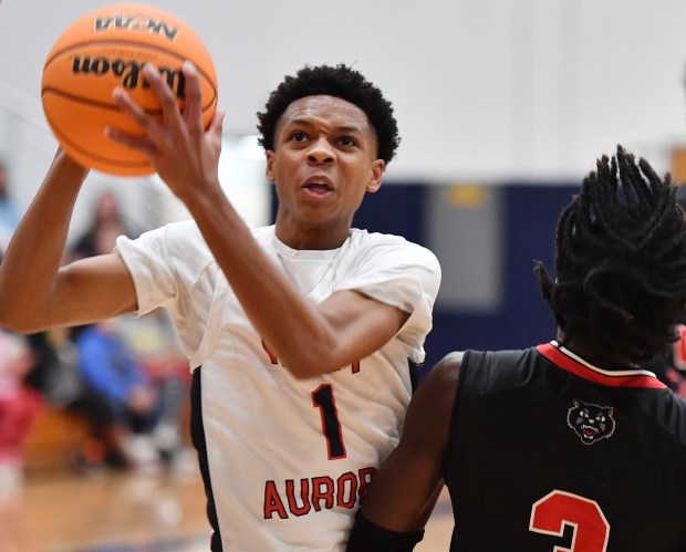 West Aurora's Travis Brown goes to the basket past East Aurora's Bryson Chandler during a game against on Friday, Dec. 20, 2024 in Aurora...(Jon Cunningham/for The Beacon-News)