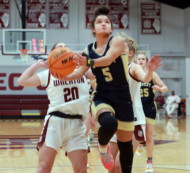 Harvest Christian Academy Daphne Brown goes for the basket as Wheaton Academy's Ava Biagini defends during the girls basketball game in West Chicago on Wednesday, Dec. 18, 2024. (James C. Svehla / Beacon News)