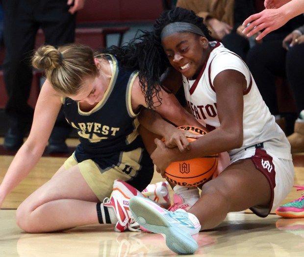 Harvest Christian Academy Sophia Johnson, left, and Wheaton Academy Alaina Fink, right, battle for the ball during the girls basketball game in West Chicago on Wednesday, Dec. 18, 2024. (James C. Svehla / Beacon News)