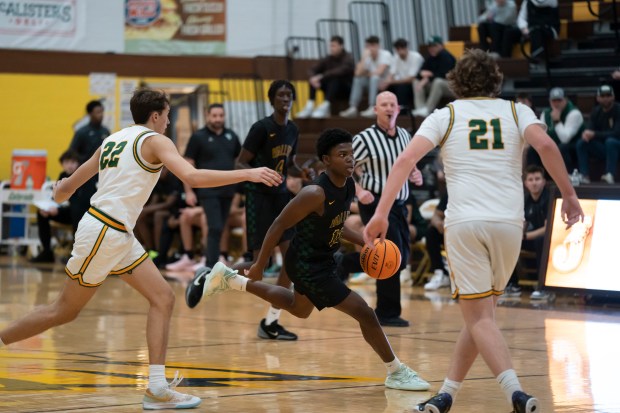 Waubonsie Valley's Tyreek Coleman dribbles down the court past Crystal Lake South's Tony Santarelli, left, and Ryan Morgan during the championship game of the 2024 Hinkle Holiday Classic basketball tournament at Jacobs High School in Algonquin on Friday, Dec. 27, 2024. (Ryan Rayburn/for the Aurora Beacon News)