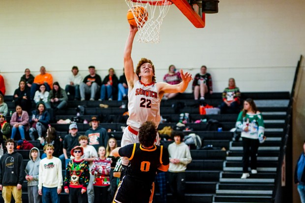 Sandwich's Dom Rome (22) drives to the hoop against Harvard's Adam Cooke (0) during a basketball game at Sandwich High School on Wednesday, Dec. 18, 2024. (Sean King / for The Beacon-News)