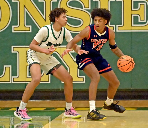 Waubonsie Valley's Kris Mporokoso guards Oswego's Dasean Patton. Waubonsie Valley defeated Oswego 76-42 in a boys basketball game Saturday, Dec. 14, 2024, in Aurora, Illinois. (Jon Langham/for the Beacon-News)