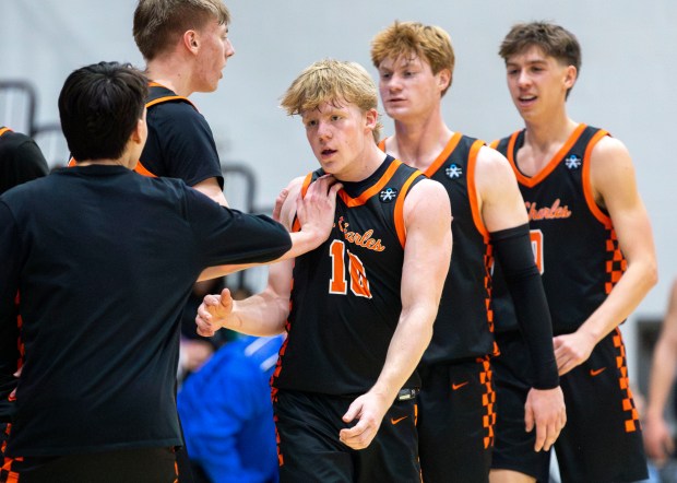 Teammates congratulate St. Charles East's Gavin Szerlong (10) following his score during a game in St. Charles on Friday, Dec. 20, 2024. (Nate Swanson / for the Beacon-News)