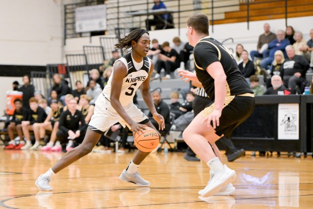 Kaneland's Fredrick Hassan (5) looks for an opening against Sycamore during a game at home in Maple Park on Wednesday, Dec. 11, 2024. (Mark Black / for the Beacon-News)