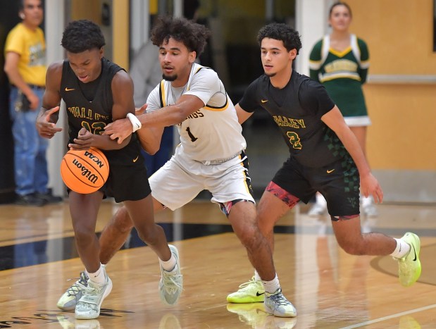 Waubonsie Valley's Tyreek Coleman is fouled by Metea Valley's Dominic Smith (1) as teammate Donovan Neal (2) moves in on the play during a game on Friday, Dec. 6, 2024 in Aurora...(Jon Cunningham/for The Beacon-News)