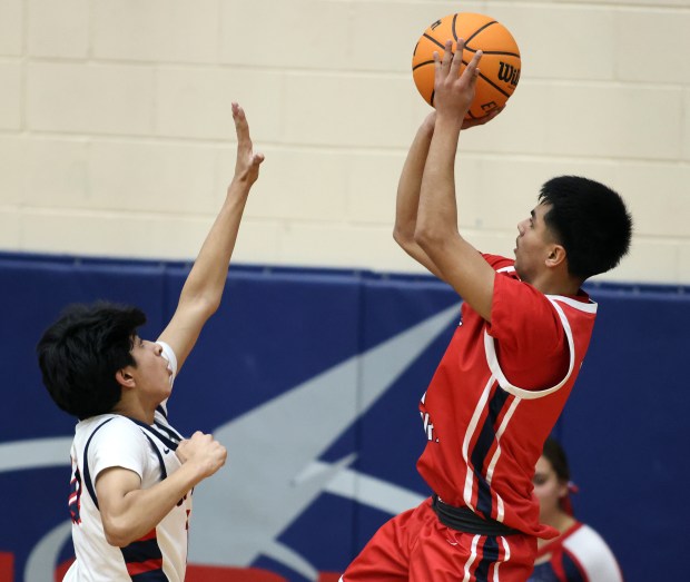 West Aurora's Abe Martinez (21) sinks a shot over South Elgin's Aman Chiluka (14) in the second quarter during a Upstate Eight conference game in South Elgin on Tuesday, Dec. 10, 2024.(H. Rick Bamman/for the Beacon-News)