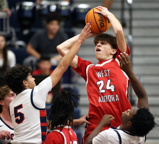 West Aurora's Gabriek Gonzles (24)shoots over South Elgin defenders Andrew Harms (5) and Damion Thurman (30) in the fourth quarter during a Upstate Eight conference game in South Elgin on Tuesday, Dec. 10, 2024.(H. Rick Bamman/for the Beacon-News)