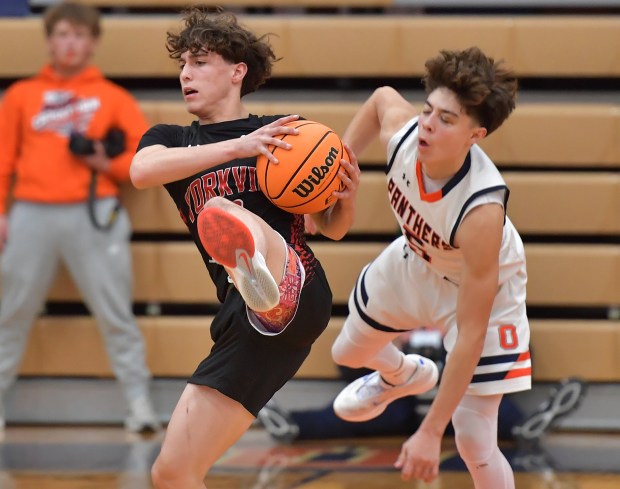 Yorkville's Gabe Sanders intercepts a pass intended for Oswego's Mariano Velasco (right) during a game on Tuesday, Dec. 10, 2024 in Oswego...(Jon Cunningham/for The Beacon-News)