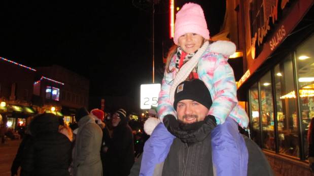 St. Charles native Bob Randazzo had his 6-year-old daughter, Olivia, perched on his shoulders so she could get a good view of the Electric Christmas Parade in St. Charles on Saturday. (Linda Girardi / For The Beacon-News)