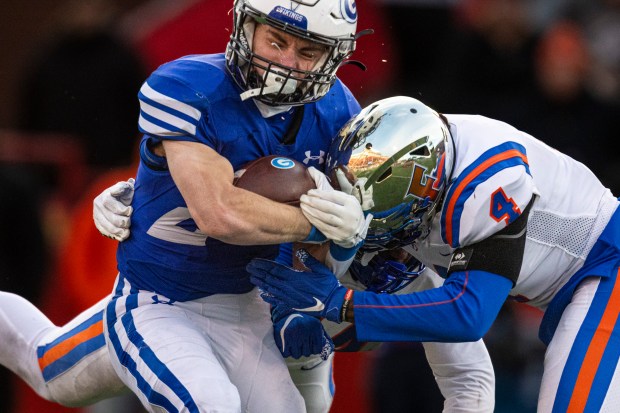 Geneva's Michael Rumoro (20) bounces off a tackle by East St. Louis's Mekhi Mixon (4) in the Class 6A state championship game at Hancock Stadium in Normal on Saturday, Nov. 30, 2024. (Vincent D. Johnson / for The Beacon-News)