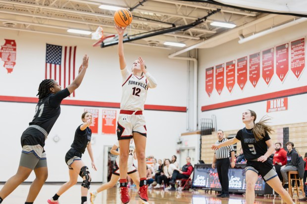 Yorkville's Lainey Gussman (12) goes up for a layup against Oswego East during a Southwest Prairie Conference game in Yorkville on Thursday, Dec. 12, 2024. (Troy Stolt / for the Beacon News)