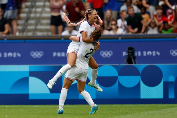 Trinity Rodman of the United States, top, celebrates after scoring the opening goal during the quarterfinal women's soccer match between the United States and the Japan at the Parc des Princes at the 2024 Summer Olympics, Saturday, Aug. 3, 2024, in Paris, France. (AP Photo/Aurelien Morissard)