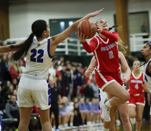 Batavia's Brooke Carlson (2) goes up for a layup against Geneva's Leah Palmer (22) during the Class 4A Glenbard West Sectional championship game in Glen Ellyn on Thursday, Feb. 23, 2023.