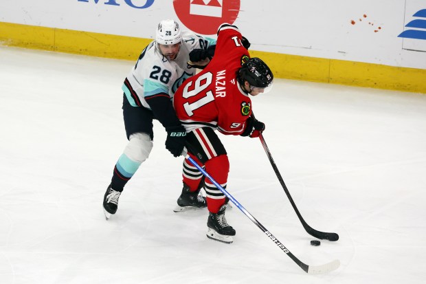 Kraken defenseman Joshua Mahura (28) challenges Blackhawks center Frank Nazar (91)in the first period at the United Center in Chicago on Dec. 19, 2024. (Terrence Antonio James/Chicago Tribune)