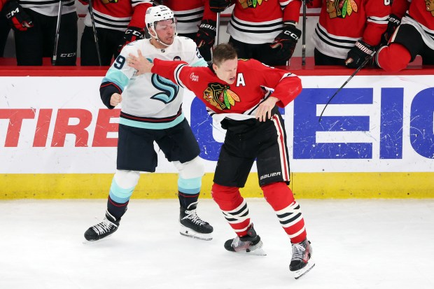 Kraken defenseman Vince Dunn (29) and Blackhawks defenseman Connor Murphy (5) fight in the second period at the United Center in Chicago on Dec. 19, 2024. (Terrence Antonio James/Chicago Tribune)