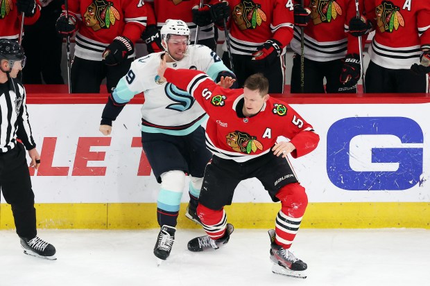 Kraken defenseman Vince Dunn (29) and Blackhawks defenseman Connor Murphy (5) fight in the second period at the United Center in Chicago on Dec. 19, 2024. (Terrence Antonio James/Chicago Tribune)